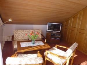 un soggiorno con tavolo, sedie e TV di Haus Huber a Wolfach