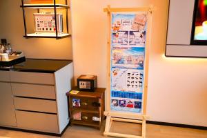 a refrigerator with a poster on the wall in a kitchen at Wanda Jin Xiaohe Xincheng in Taiyuan