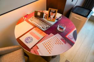 a round table with a laptop and a keyboard at Wanda Jin Xiaohe Xincheng in Taiyuan