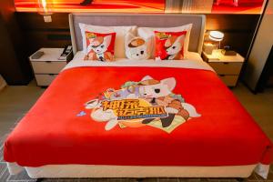 a bed with a red blanket with hello kitty on it at Wanda Jin Xiaohe Xincheng in Taiyuan