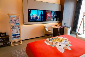 a bedroom with a bed with a television on the wall at Wanda Jin Xiaohe Xincheng in Taiyuan