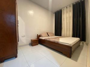 a small bedroom with a bed and a window at BIZI HOMES in Kigali