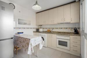 una cucina con mobili bianchi e un tavolo di Castillo sohail townhouse near the beach by Costarentals - Ref 101 a Fuengirola