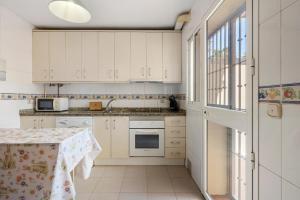una cucina con mobili bianchi e un tavolo di Castillo sohail townhouse near the beach by Costarentals - Ref 101 a Fuengirola