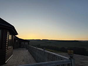 a balcony of a house with the sunset in the background at Auchenhill Lodge in Denny
