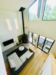 a living room with a couch and some windows at Kinagashi Happo Chalet West in Hakuba