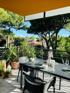 a table and chairs on a patio with trees at Damiano Chiesa terrazzato -Flexrent Immobiliare Abissinia in Riccione