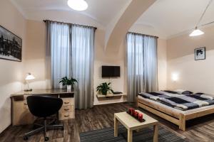 1 dormitorio con cama, escritorio y silla en Accommodation Smečky 14, en Praga