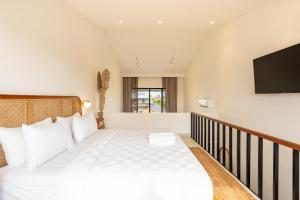 Un dormitorio con una cama y un televisor de pantalla plana. en Karra 8 Apartment by Betterplace, en Canggu 39 fotos más