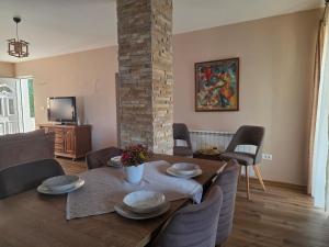 a living room with a table and chairs and a tv at Wildstone Krusi - Pool & Apartments 1 in Podgorica