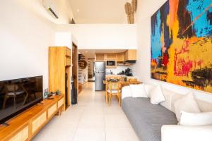 Una sala de estar con un sofá y una cocina. en Karra 8 Apartment by Betterplace, en Canggu