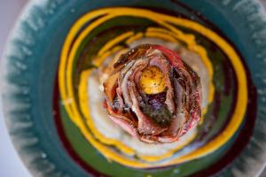 a piece of food on a plate with sauce at Hôtel - Restaurant U Santu Petru in Saint-Florent