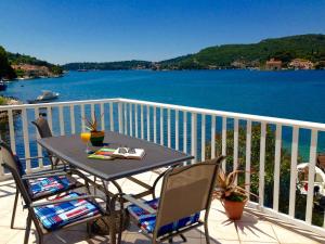 einen Tisch und Stühle auf einem Balkon mit Blick auf das Wasser in der Unterkunft Apartments Capitano Blue in Zaton