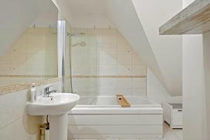 a white bathroom with a sink and a bath tub at Pentire Point - Coastal Penthouse, Beaches, River & Restaurants All Within Short Walk in Newquay