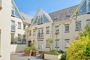 an apartment building with a courtyard with plants at Pentire Point - Coastal Penthouse, Beaches, River & Restaurants All Within Short Walk in Newquay