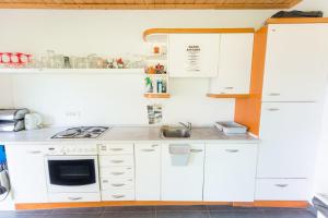 a kitchen with white cabinets and a stove top oven at Apartma Jernej in Bovec +25 photos