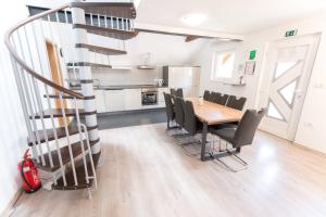 a dining room with a table and chairs and a spiral staircase at Apartma Jernej in Bovec