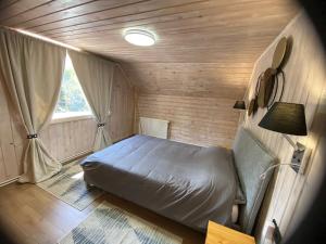 Un dormitorio pequeño con una cama y una ventana. en Vila Dani&Marina, en Porumbacu de Sus