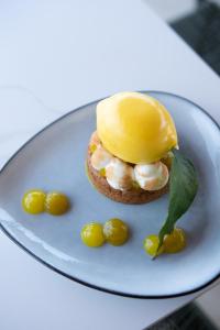 a sandwich on a plate with lemons on a table at Hôtel - Restaurant U Santu Petru in Saint-Florent