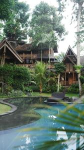 una casa con un estanque delante de ella en Green Tree House Villa Ubud, en Ubud
