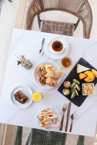 a white table with plates of food on it at Hôtel - Restaurant U Santu Petru in Saint-Florent
