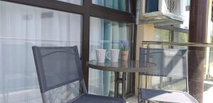 a glass table and two chairs on a balcony at Saturn Alfa Residence - 2 Rooms Apartment in Saturn