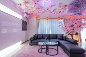a living room with a couch and pink ceilings at Otter Stay - Sakou in Nagoya