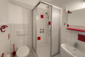 a bathroom with a shower and a toilet and a sink at BoardingHouse - Studios & Apartments in Kassel