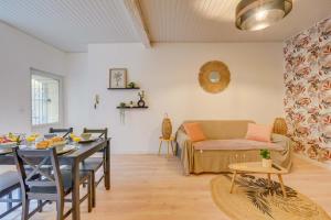 a living room with a table and a couch at Charmante maison au cœur de Libourne in Libourne