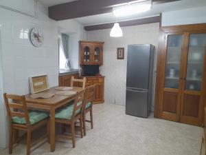 a kitchen with a wooden table and a refrigerator at Casa Cotiellu in Llanes