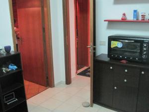 - une cuisine avec un four micro-ondes au-dessus d'une armoire dans l'établissement Appartamento Mare, à Letojanni