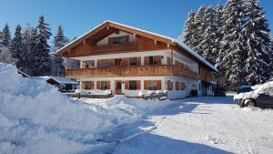 una casa con molta neve davanti di Ferienwohnungen Lohbinder Fam Holzer a Rottach-Egern