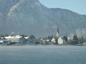 una città con una chiesa di fronte a una montagna di Ferienwohnungen Lohbinder Fam Holzer a Rottach-Egern