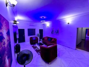 a living room with purple lighting and two couches at Home in Abuja Municipal Area Council in Abuja