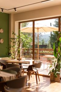 a restaurant with tables and chairs and a large window at Pensiunea Bucuria Cheia & Ferma Animale in Cheia