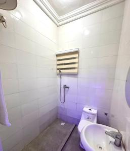 a white bathroom with a sink and a toilet at Home in Abuja Municipal Area Council in Abuja