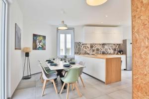 a kitchen and dining room with a table and chairs at Villa au pied de la plage in Les Sables-dʼOlonne