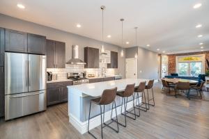 Una cocina con una gran isla con taburetes de bar. en Parkside Comfort | JZ Vacation Rentals, en Tower Grove