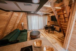 Una sala de estar con un sofá verde y una mesa. en Ośrodek Wypoczynkowy Nad Leśną Wodą, en Bystrzyca