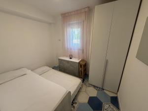 a small room with two beds and a window at Beach House Ponente in Erchie