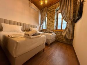 a bedroom with two beds and a window at Submarine 105 Rooms in Gjirokastër