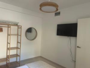 Habitación con pared, TV y estante. en Luxury homes bajo laguna beach and pool vera, en Los Amarguillos