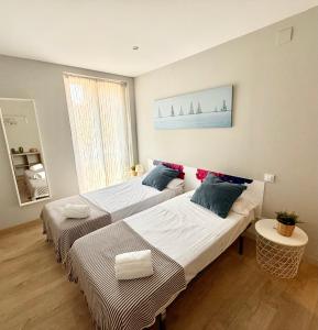 two beds in a small room with a window at Vive Zaragoza XV in Zaragoza