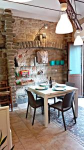 a table and chairs in a room with a stone wall at Nicola appartamento in Giba