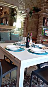 a white table with plates and wine glasses on it at Nicola appartamento in Giba