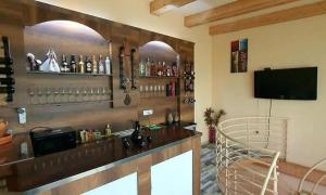 un bar con barra y TV en una habitación en City house kutaisi - vintaje, en Kutaisi