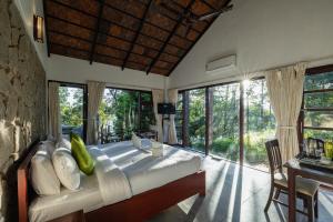 ein Schlafzimmer mit großem Bett und großen Fenstern in der Unterkunft Avadale Munnar (Stag Groups Not Allowed) in Chinnakanal
