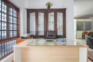 an office with a glass desk and a chair at Hotel O Krupa Service Apartments in Hyderabad