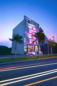 a building with purple lights on the side of a street at favehotel Graha Agung Surabaya in Surabaya