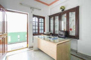 an office with a desk and a chair and a window at Hotel O Krupa Service Apartments in Hyderabad